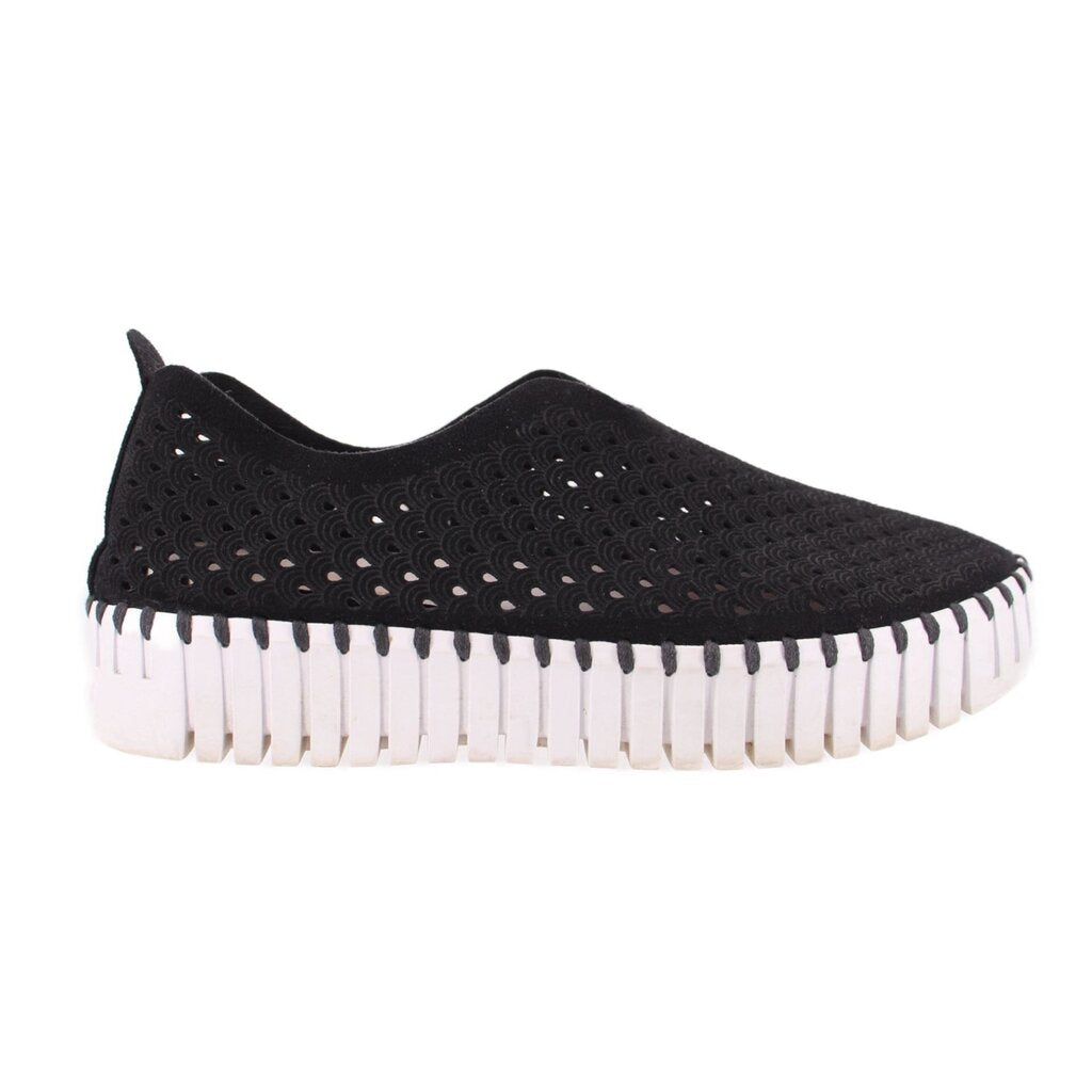 Black cutout slip-on flats with perforated pattern and striped white outsole edge