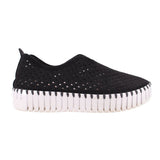 Black cutout slip-on flats with perforated pattern and striped white outsole edge