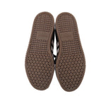 Pair of gum rubber outsole soles with textured tread on black sneakers