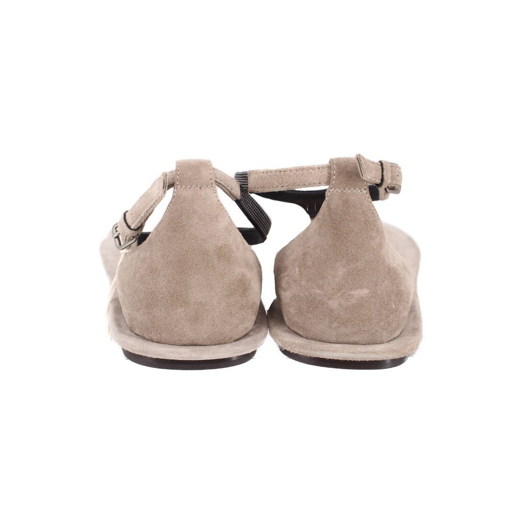 Light gray suede sandals with adjustable ankle straps and dark rubber sole