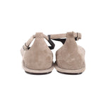 Light gray suede sandals with adjustable ankle straps and dark rubber sole