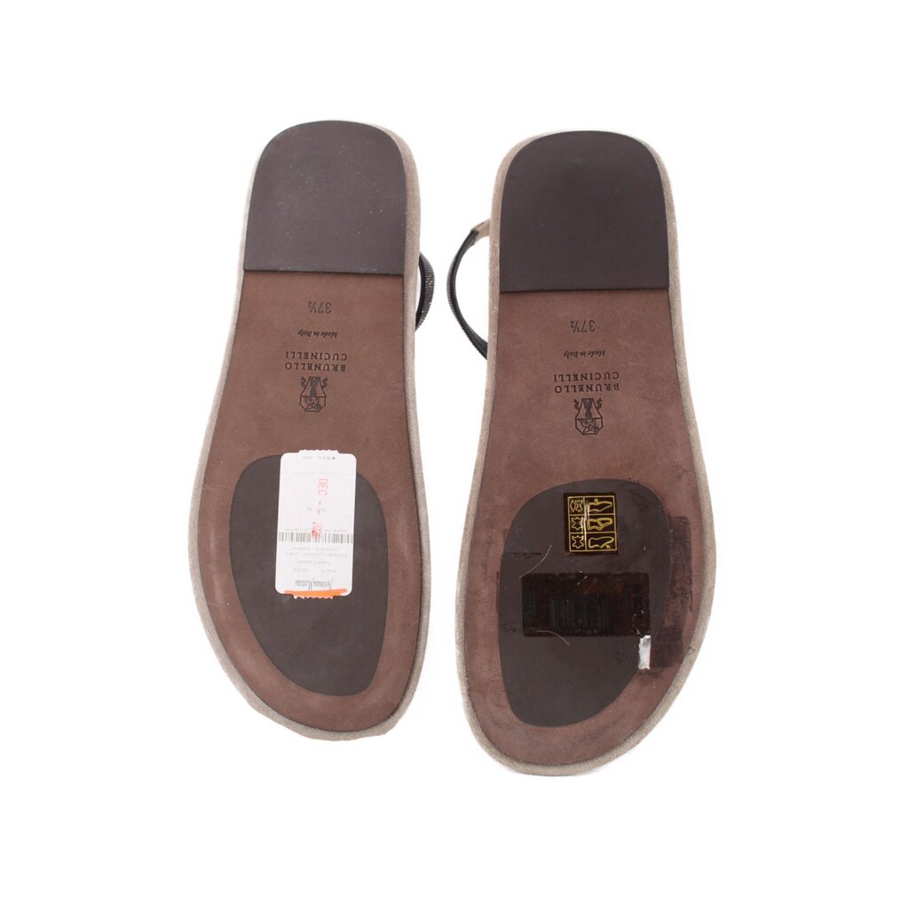 Undersides of light gray suede sandals with brand markings and outsole