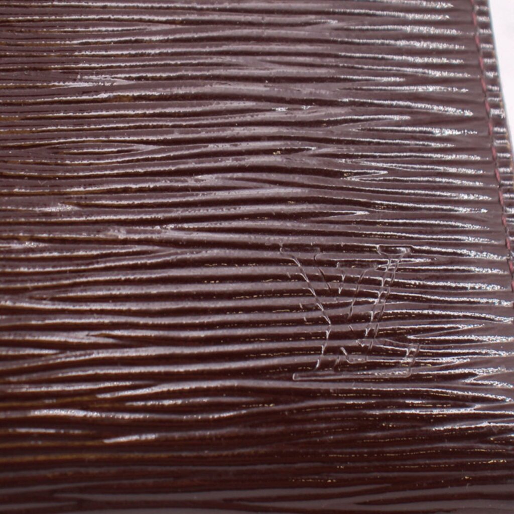 LOUIS VUITTON Epi leather close-up, maroon textured grain on zip wallet surface
