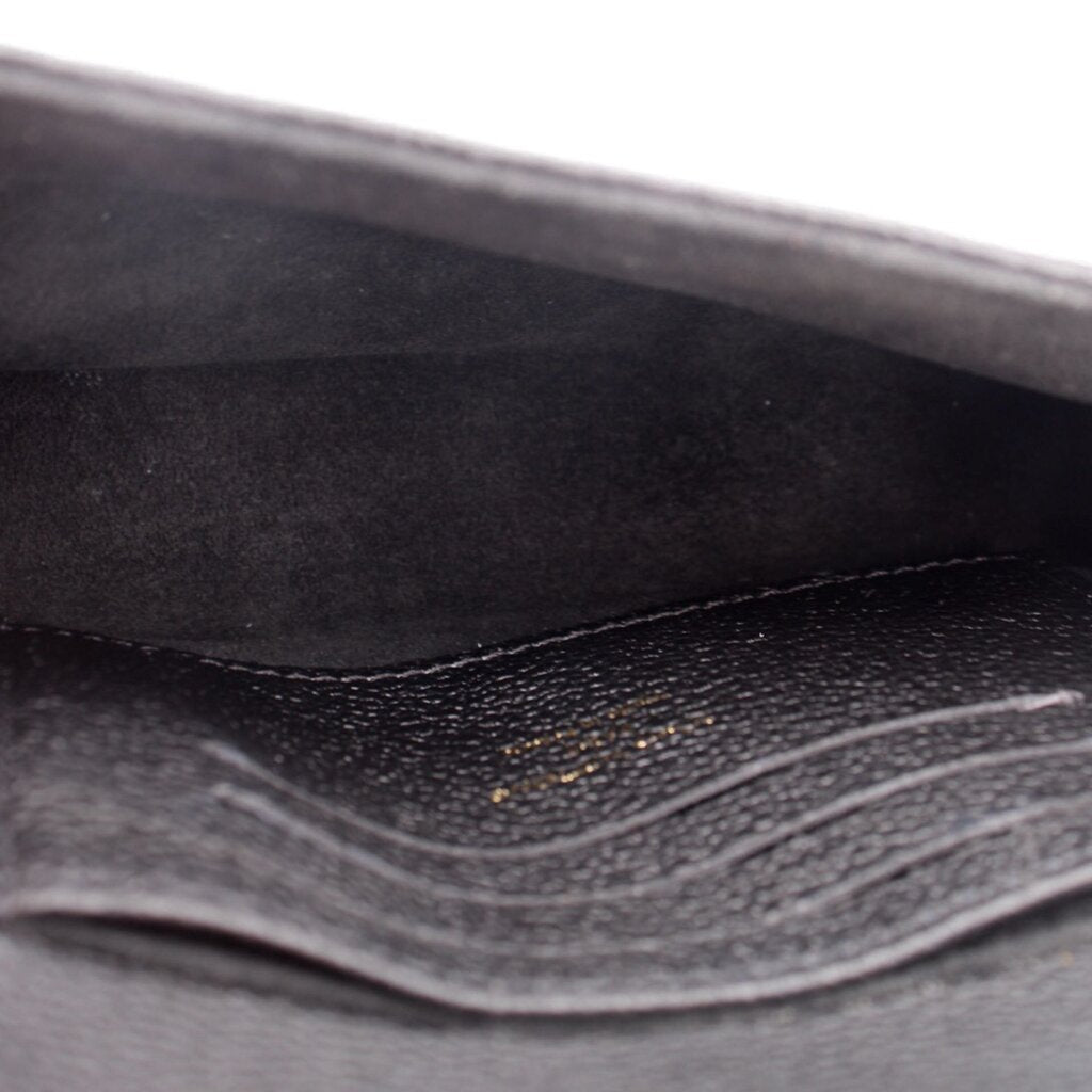 Black interior lining of a small crossbody bag with visible stitching