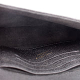 Black interior lining of a small crossbody bag with visible stitching