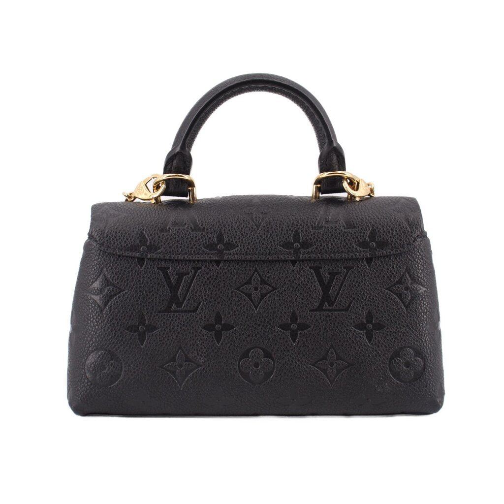 Black monogram mini flap crossbody bag with gold top handles and embossed pattern