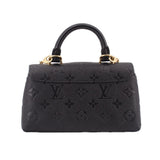 Black monogram mini flap crossbody bag with gold top handles and embossed pattern