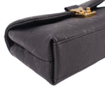 Black leather mini bag corner with smooth flap edge and gold clasp hardware