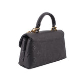 Black monogram mini flap crossbody bag with gold chain detail and structured sides