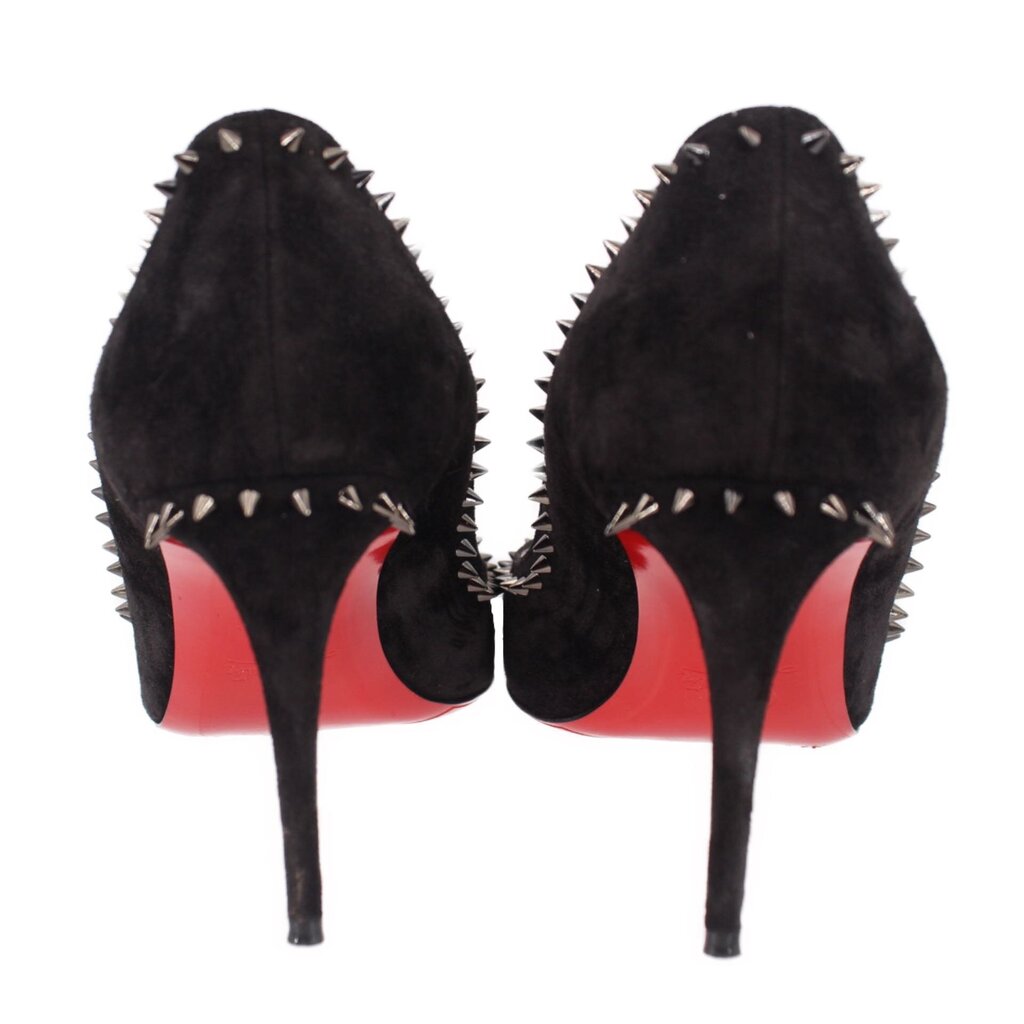 Black suede spike-heel pumps from heel view with red outsole and studded sides