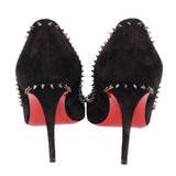 Black suede spike-heel pumps from heel view with red outsole and studded sides