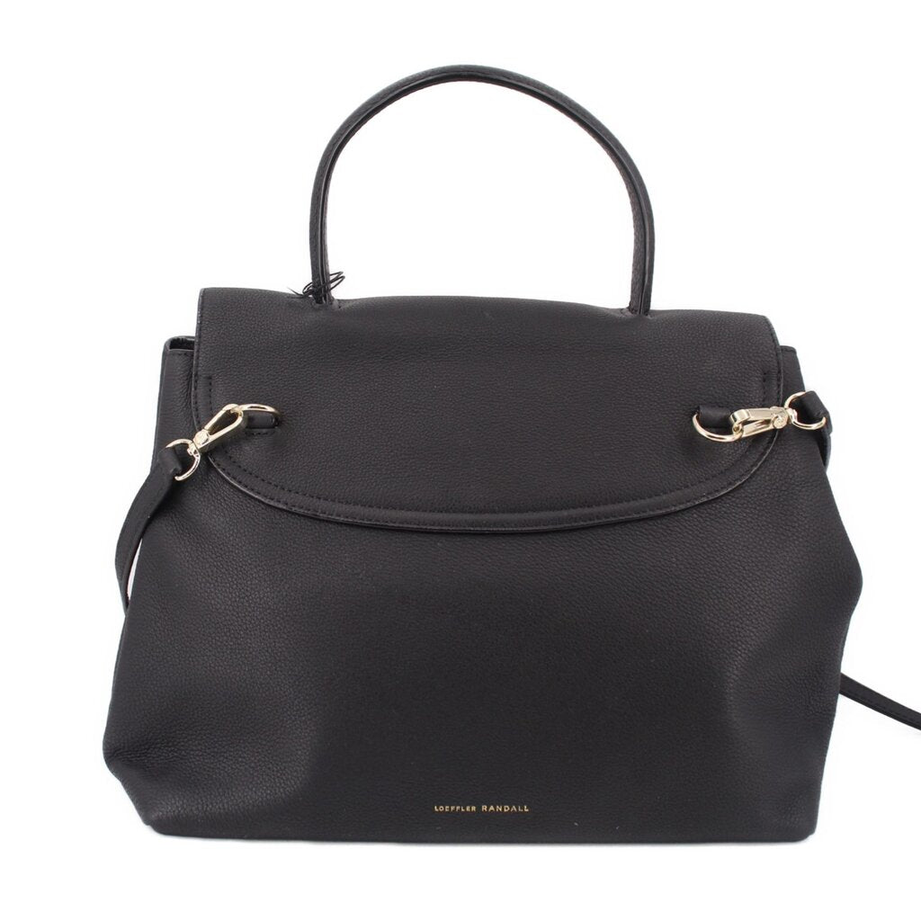 Carina crossbody bag with black flap front, gold-tone rings, and top handle.