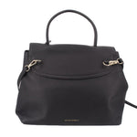 Carina crossbody bag with black flap front, gold-tone rings, and top handle.
