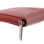 CHANEL red zip-around wallet side close-up with CHANEL zipper tag