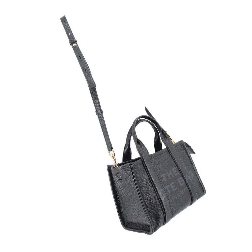 Small black leather tote bag with adjustable crossbody strap and top handles