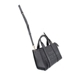 Small black leather tote bag with adjustable crossbody strap and top handles
