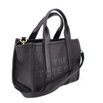 Small black leather tote bag with structured sides and crossbody strap, gold-tone clasp