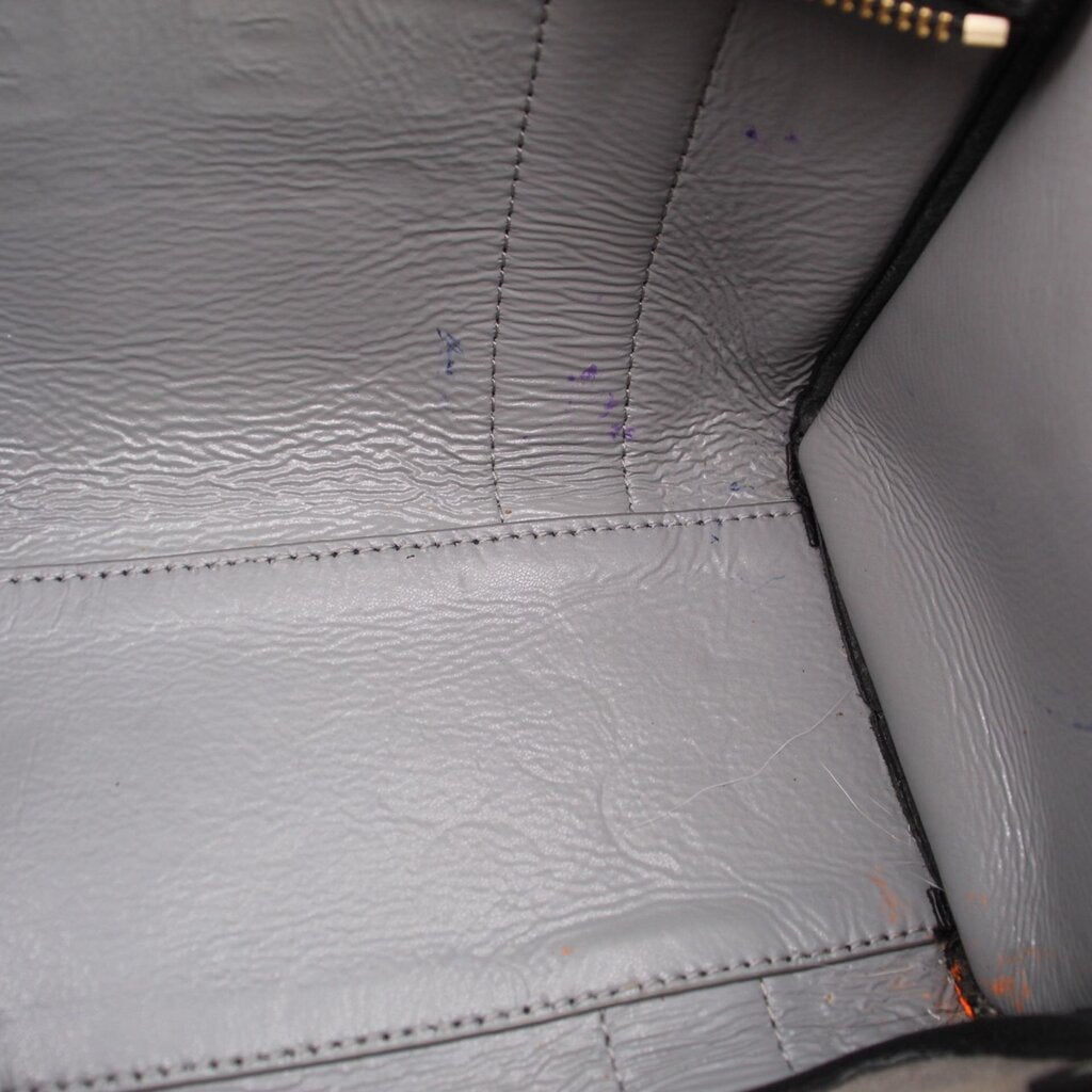 Interior lining detail of black tote bag with stitched seams and textured finish
