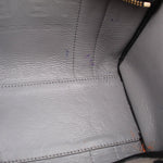 Interior lining detail of black tote bag with stitched seams and textured finish