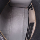 Interior view of black leather tote bag with zip pocket and gold-tone zipper trim