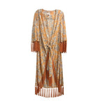 Orange fringe jacket with light floral print, tassel cuffs and hem