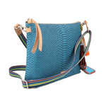 Teal crossbody bag with tan top handle, striped strap, and tassel charm