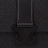 Black leather flap clasp and hardware detail on messenger crossbody bag