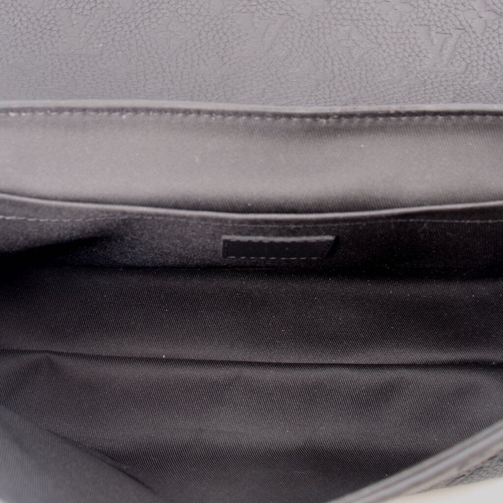 Black fabric interior lining of a black messenger crossbody bag
