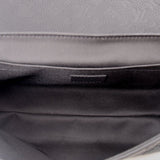 Black fabric interior lining of a black messenger crossbody bag