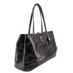 Black kisslock tote bag, angled view, patterned logo design and top handles