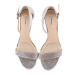 Pair of silver metallic heeled sandals with ankle strap and open-toe design