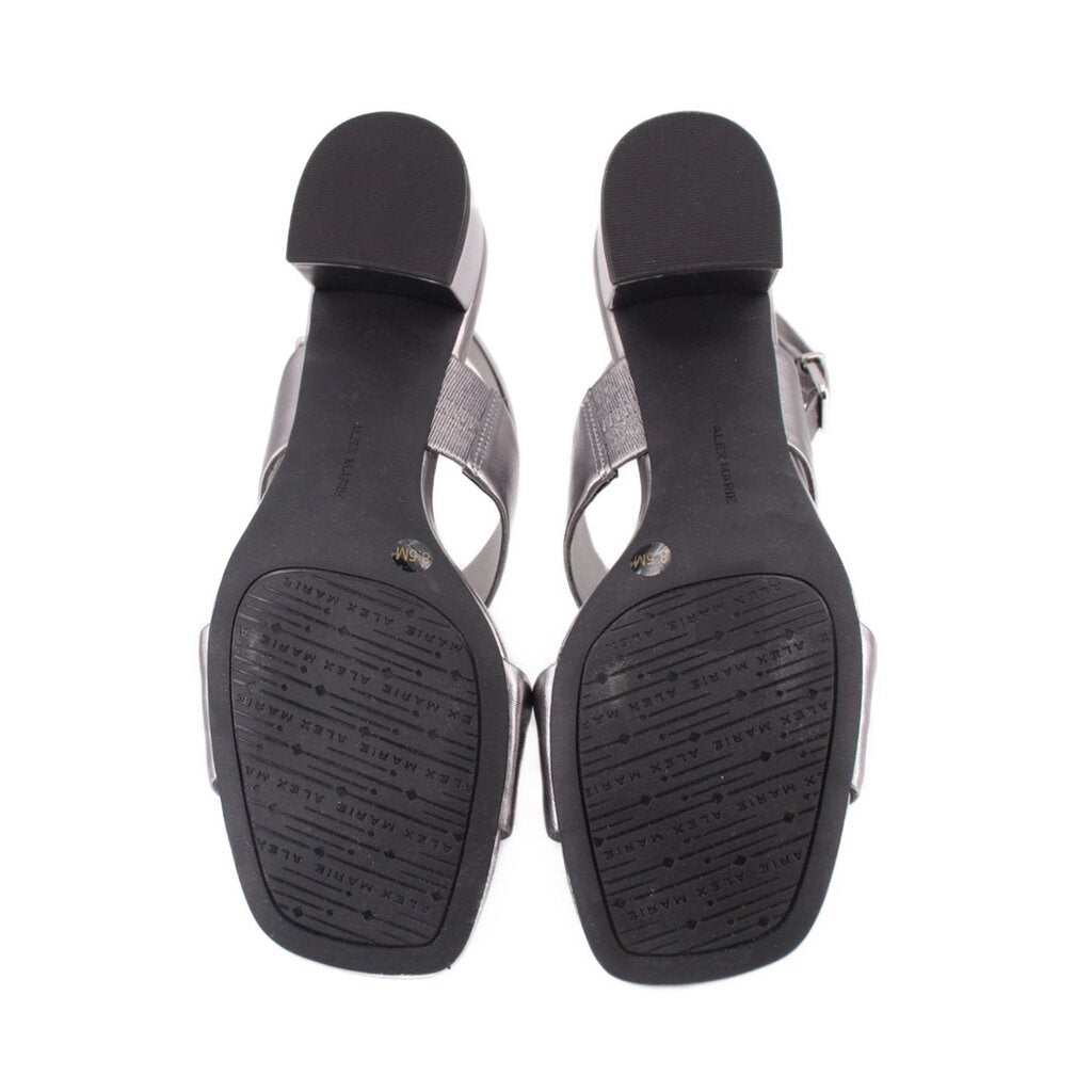Pewter metallic leather sandals with black textured outsoles and attached ankle straps