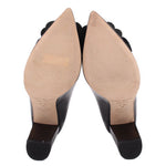 Black patent heeled pumps showing insoles and outsoles; floral toe applique