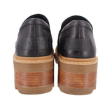 Black leather loafer heels with embossed logo on heel and tan stacked sole
