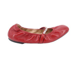 Red leather flats, side view with rhinestone-adorned strap and buckle detail.