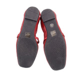 Red leather flats outsole view with black patterned tread and WEITZMAN text.
