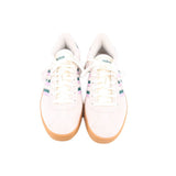 Cream Adidas sneakers with lace-up front and green heel accents plus purple stripe panels