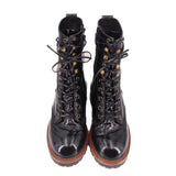 Pair of black glossy lace-up ankle boots with gold eyelets and brown rubber soles
