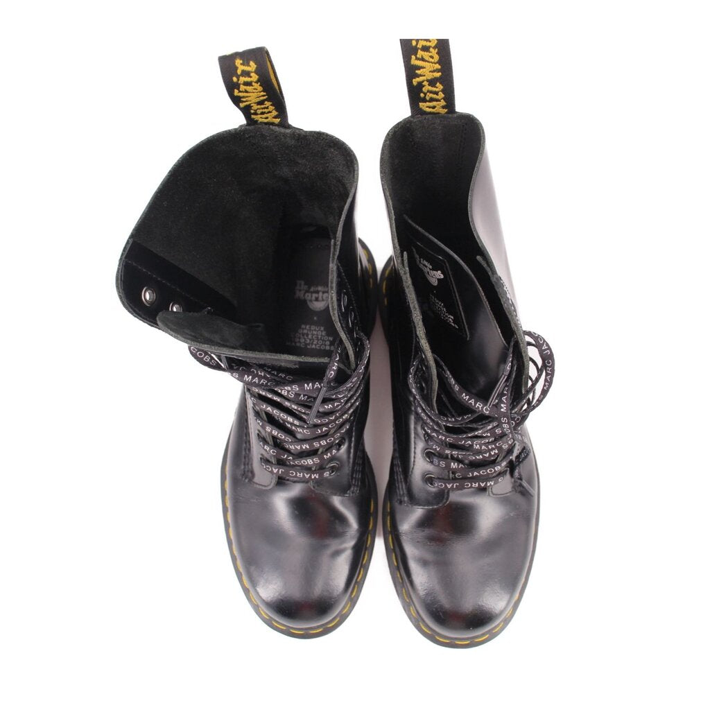 Black lace-up boots with plush lining and yellow logo text on tongue