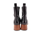 Black patent ankle boots with side zipper, pull tab, and brown block heel