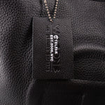 Telfar logo brand tag on black leather bag interior, with small product text