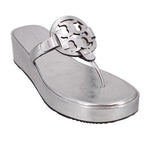 Silver Miller sandals with cutout logo t-strap and thong-style platform wedge sole.