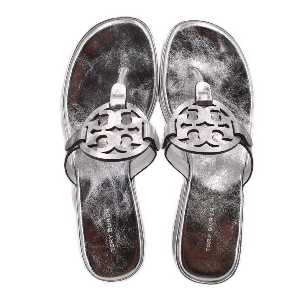 Pair of silver thong sandals with cutout logo strap and cushioned footbeds.
