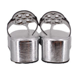 Silver platform wedge sandal heels with openwork logo straps, back view.