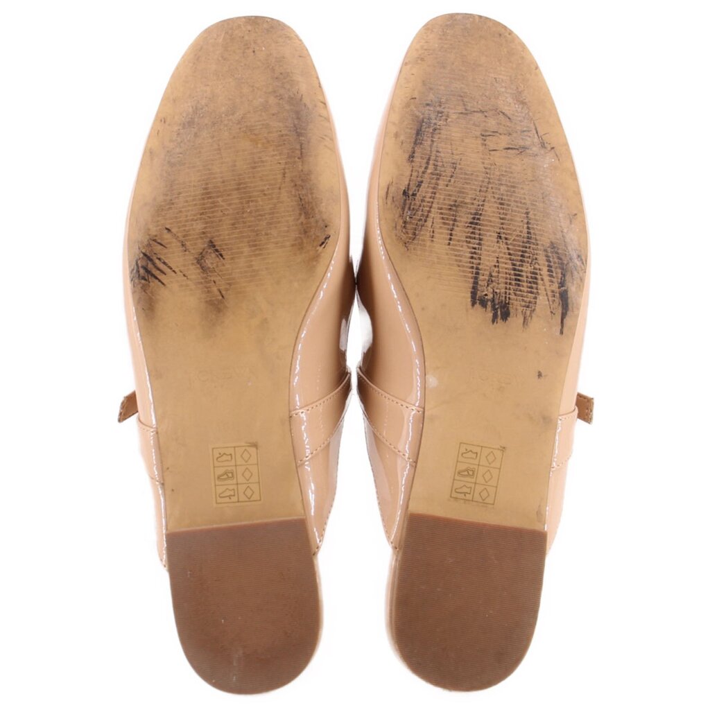 Tan patent flat outsoles with embossed markings on the heel and forefoot
