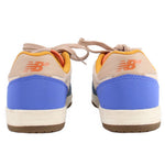 Back view of blue New Balance tennis sneakers with orange logo and tan heel