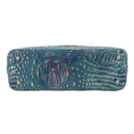 Blue embossed leather satchel with wide flap, front snap, and circular emblem