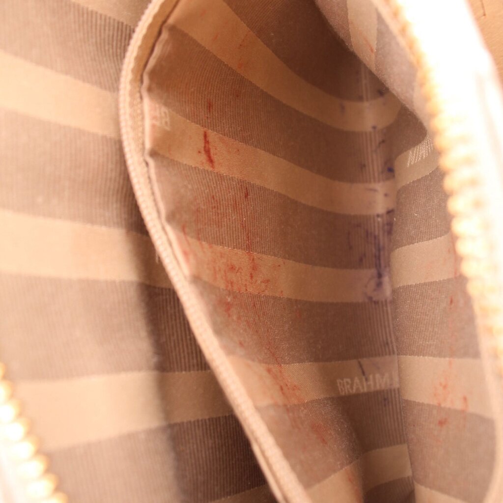 Striped fabric lining inside crossbody bag with BRAHMIN logo stamp on panel.