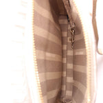Inside crossbody bag with striped fabric lining and metal zipper pull on pocket.