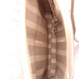 Inside crossbody bag with striped fabric lining and metal zipper pull on pocket.